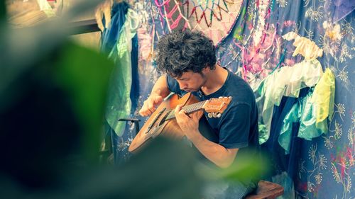 Full length of young man playing guitar