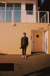 Portrait of young man standing against building