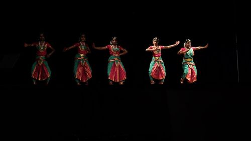 People dancing against black background