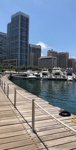 Modern buildings by sea against clear sky