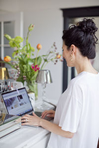 Smiling woman using laptop at home