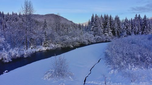 Scenic view of snow covered land against sky