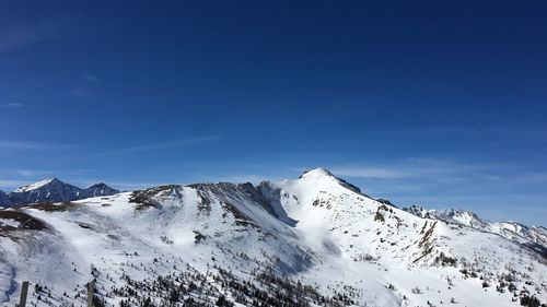 Scenic view of snowcapped mountains against blue sky