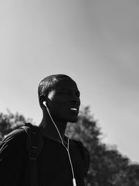 Low angle view of man with umbrella against sky