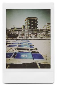 Buildings by swimming pool in city against sky