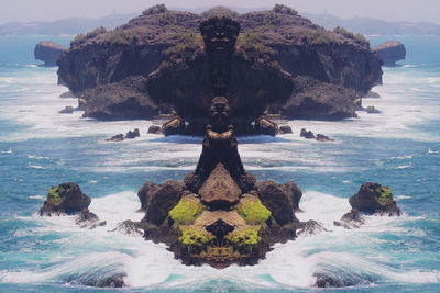 Digital composite of rock formation in sea against sky