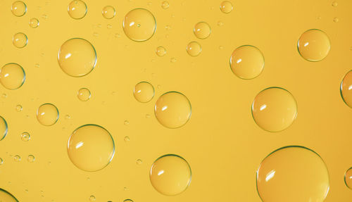 Full frame shot of bubbles on yellow background