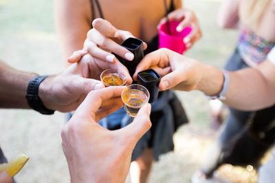 High angle view of men and women toasting shot glasses