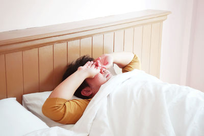 Midsection of man sleeping woman lying on bed