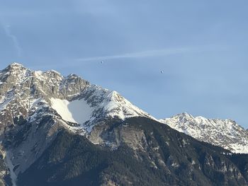 Low angle view of snowcapped mountains against sky