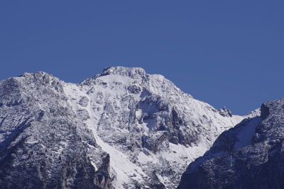 Scenic view of snowcapped mountains against clear blue sky