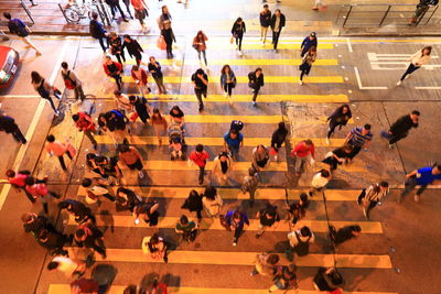 High angle view of people crossing road in city at night