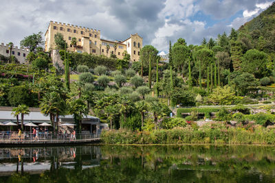 View of trees by lake against building