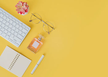 Directly above shot of computer keyboard against yellow background