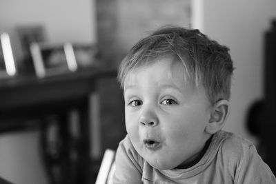 Portrait of cute baby boy making face at home