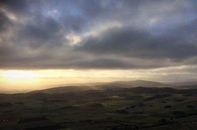 Scenic view of agricultural field against dramatic sky