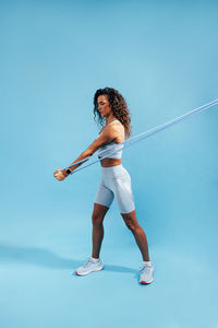 Full length of woman against blue background