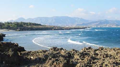 Scenic view of sea and mountains against sky