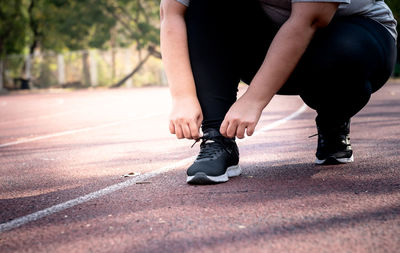 Low section of woman standing on road