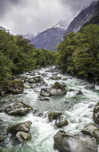 Scenic view of river amidst mountains against sky