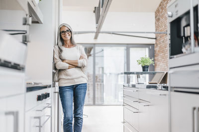 Smiling woman with long grey hair in kitchen