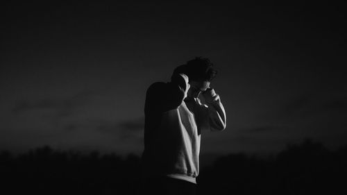 Side view of silhouette man standing against sky