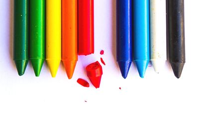 Close-up of colored pencils over white background