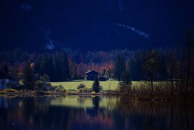 Scenic view of lake in forest against sky during autumn