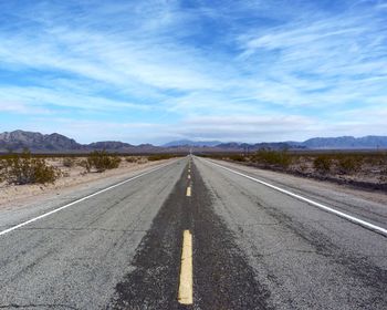 Empty road along countryside landscape