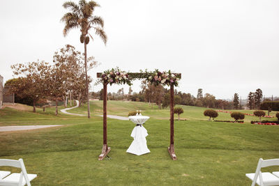 Outdoor wedding ceremony on a cloudy rainy day - wooden square arch with floral arrangements