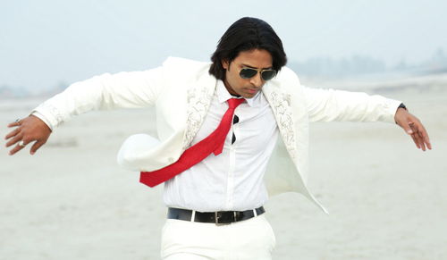 Man wearing white suit on the beach