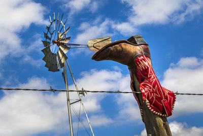 Low angle view of animal sculpture against cloudy sky