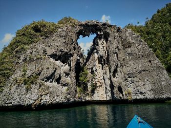 Rock formations in water against sky, 