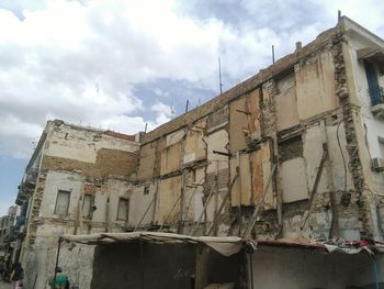 Low angle view of building against cloudy sky