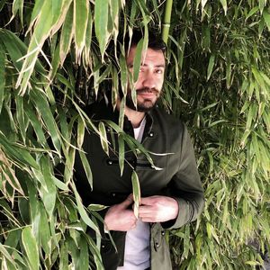 Portrait of man standing by plants