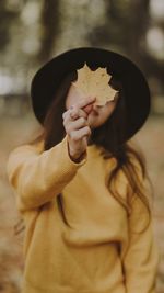 Midsection of woman holding hat