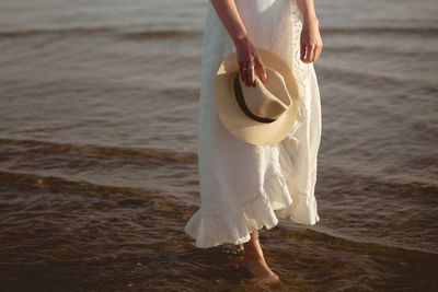 Low section of woman standing on beach