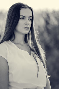 Portrait of young woman standing against sky