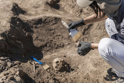 Anthropology. anthropologist holding ancient human bones recovered from burial site.