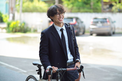 Side view of young man standing on road