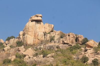 Low angle view of stone wall against clear blue sky