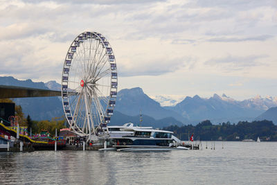 Ferris wheel by mountains against sky