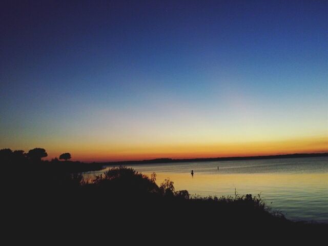 sunset, silhouette, tranquil scene, scenics, water, tranquility, copy space, beauty in nature, sea, clear sky, nature, idyllic, orange color, sky, dusk, horizon over water, calm, blue, lake, outdoors