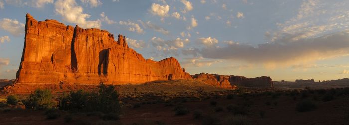 Rock formations on landscape against cloudy sky