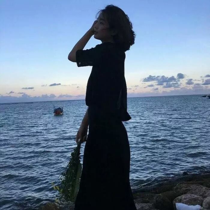 WOMAN STANDING ON BEACH