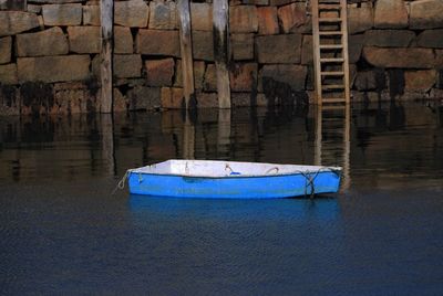 Boats moored on rocks at sea shore