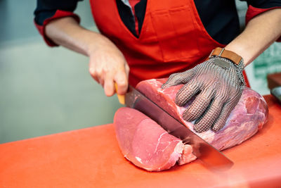 Midsection of woman cutting meat at restaurant