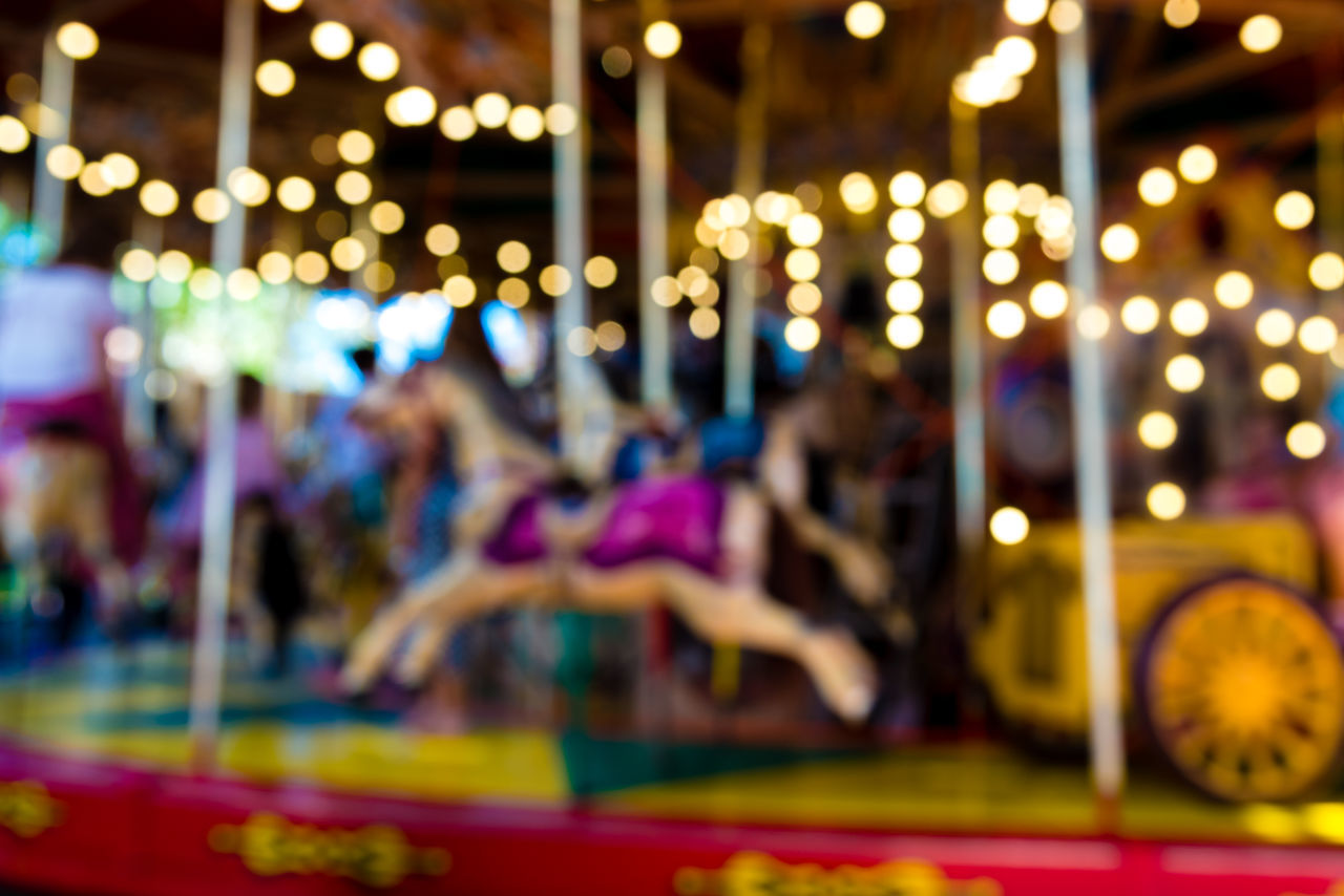 ILLUMINATED CAROUSEL AT AMUSEMENT PARK