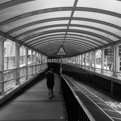 Rear view of woman walking on railroad station