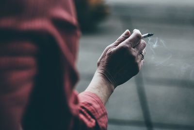 Close-up of hand holding cigarette